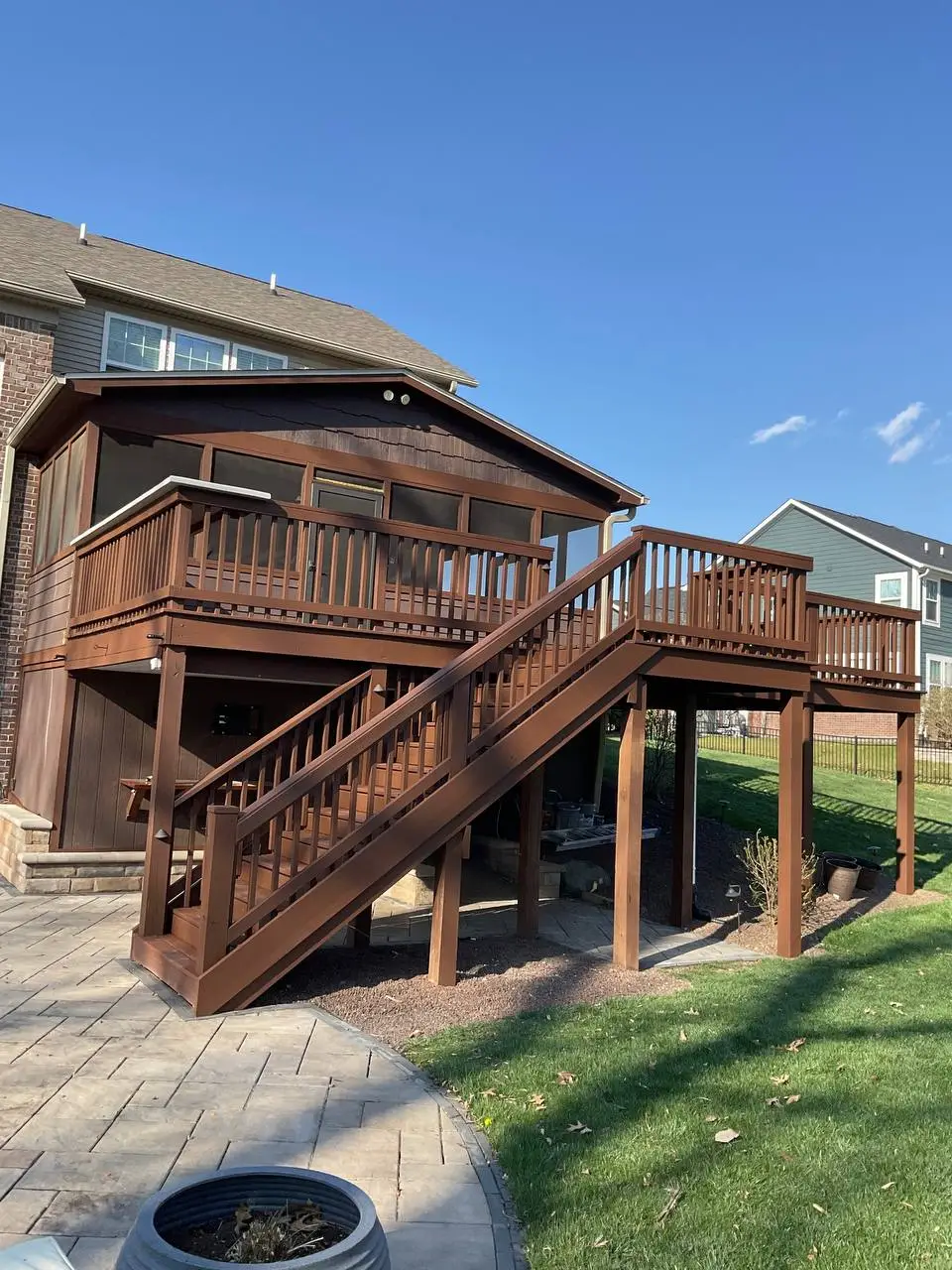 Newly stained wooden deck and screened porch addition on a suburban home