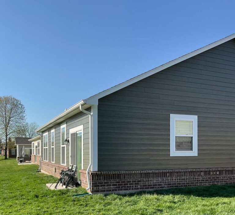 Modern home exterior with dark siding and white trim, suitable for residential painting.