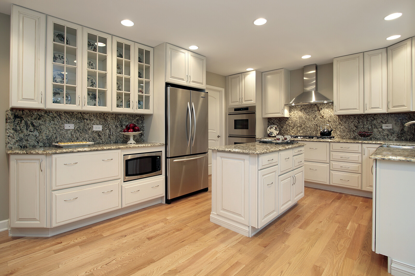 White kitchen with granite countertops, stainless steel appliances, and island