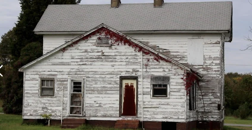 Peeling white paint on an old house, a reminder to paint before winter.