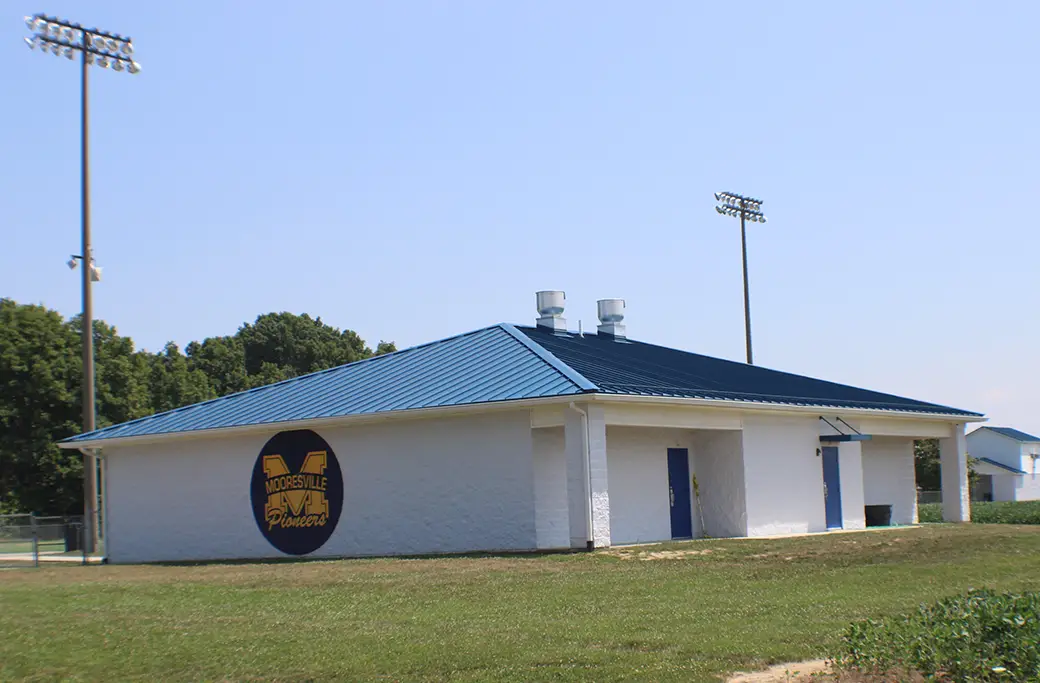 Mooresville Pioneers building with blue roof and stadium lights
