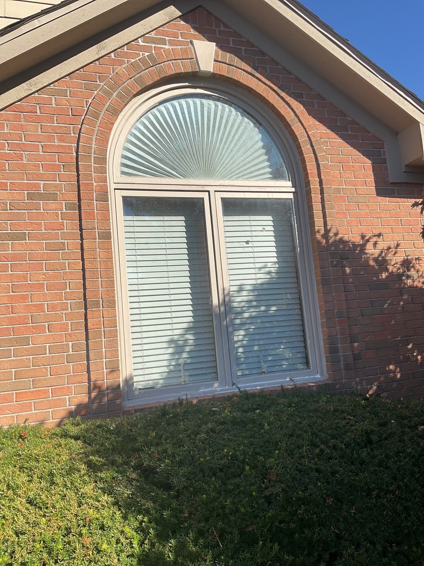 Arched Brick Window With Blinds Lawton Residence: Arched window above double-hung windows on brick house