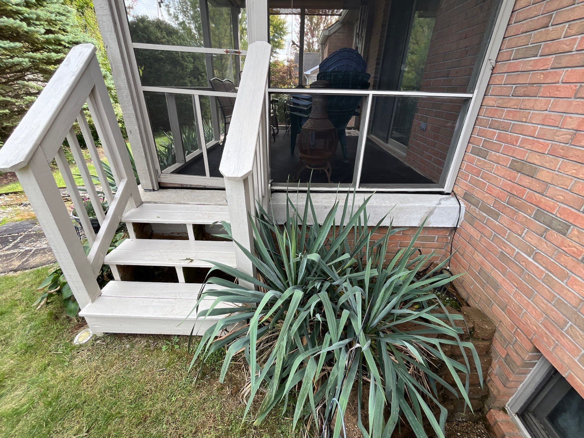 Backyard Deck Stairs With Yucca Plant Lawton Residence exterior: Painted stairs, brick house, and large yucca plant.