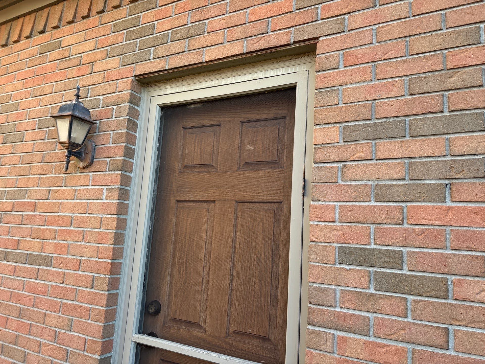 Brick House Entry Door With Light Lawton Residence exterior: wooden door and brick wall with lamp