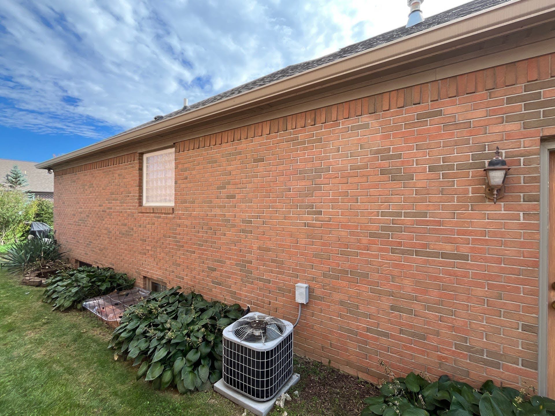 Brick House Exterior Air Conditioner Unit Lawton Residence exterior: brick wall, AC unit, and landscaping.