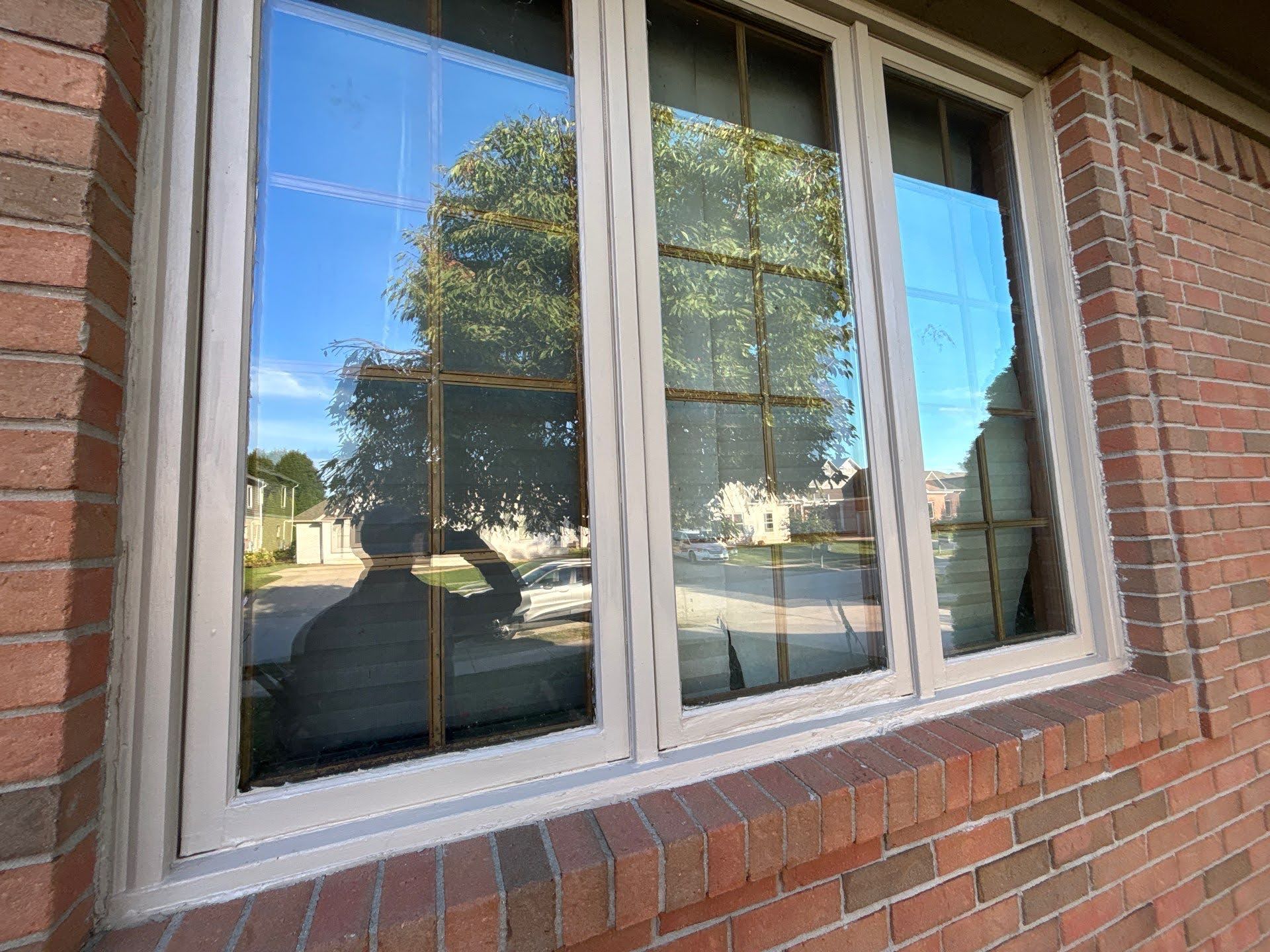 Brick House Window Reflection Tree Exterior painting of Lawton Residence windows with brick exterior.
