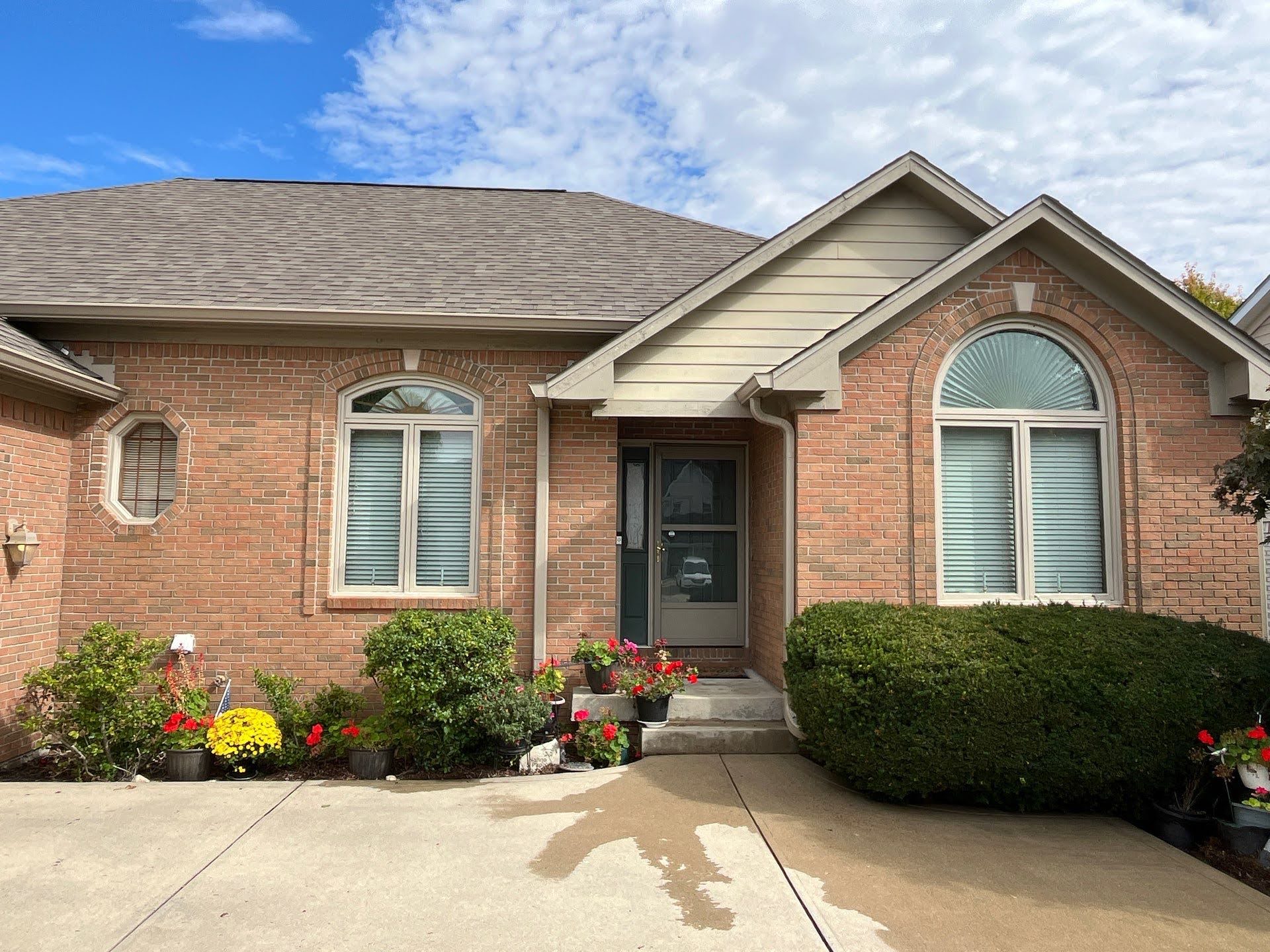 Brick Townhouse Front Door With Flowers Lawton Residence exterior: brick home with arched windows and landscaping