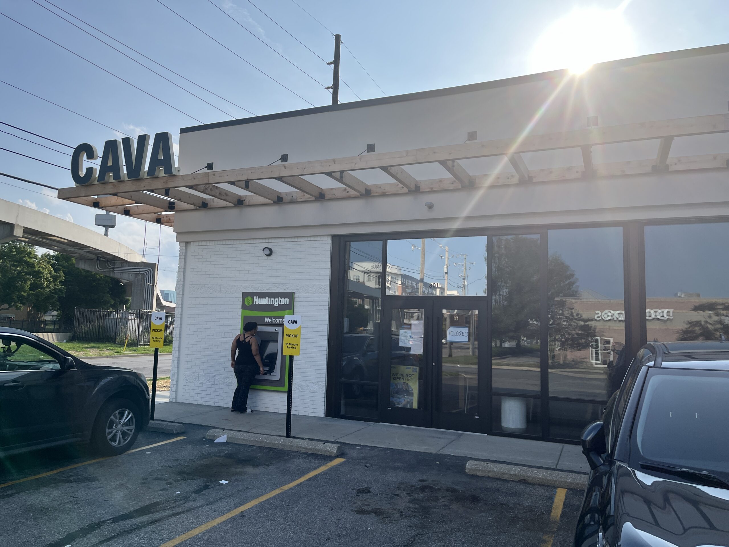 Cava Restaurant Atm Pickup Window CAVA exterior with wooden canopy, ATM, and parked cars