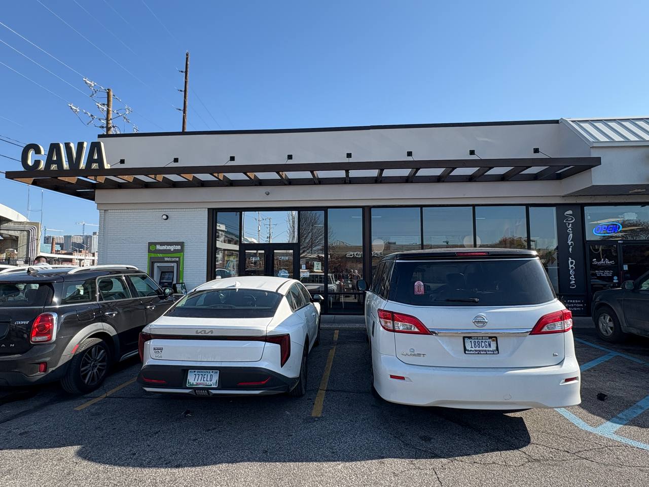 Cava Restaurant Exterior Parking Lot Vehicles CAVA restaurant exterior with cars parked in front, showing a white canopy