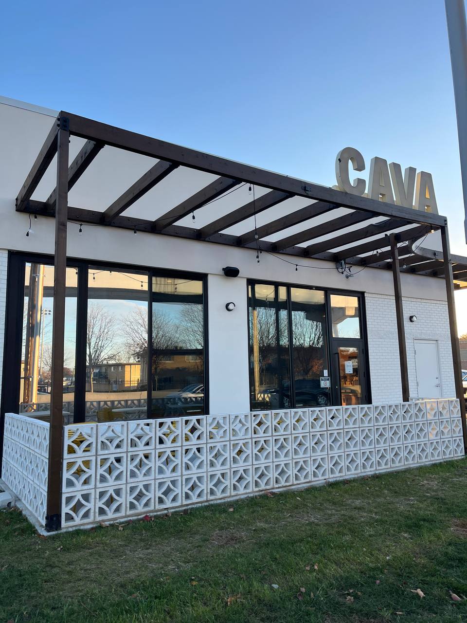 Cava Restaurant Exterior With Pergola And Block Wall CAVA restaurant exterior with wooden canopy and white brick