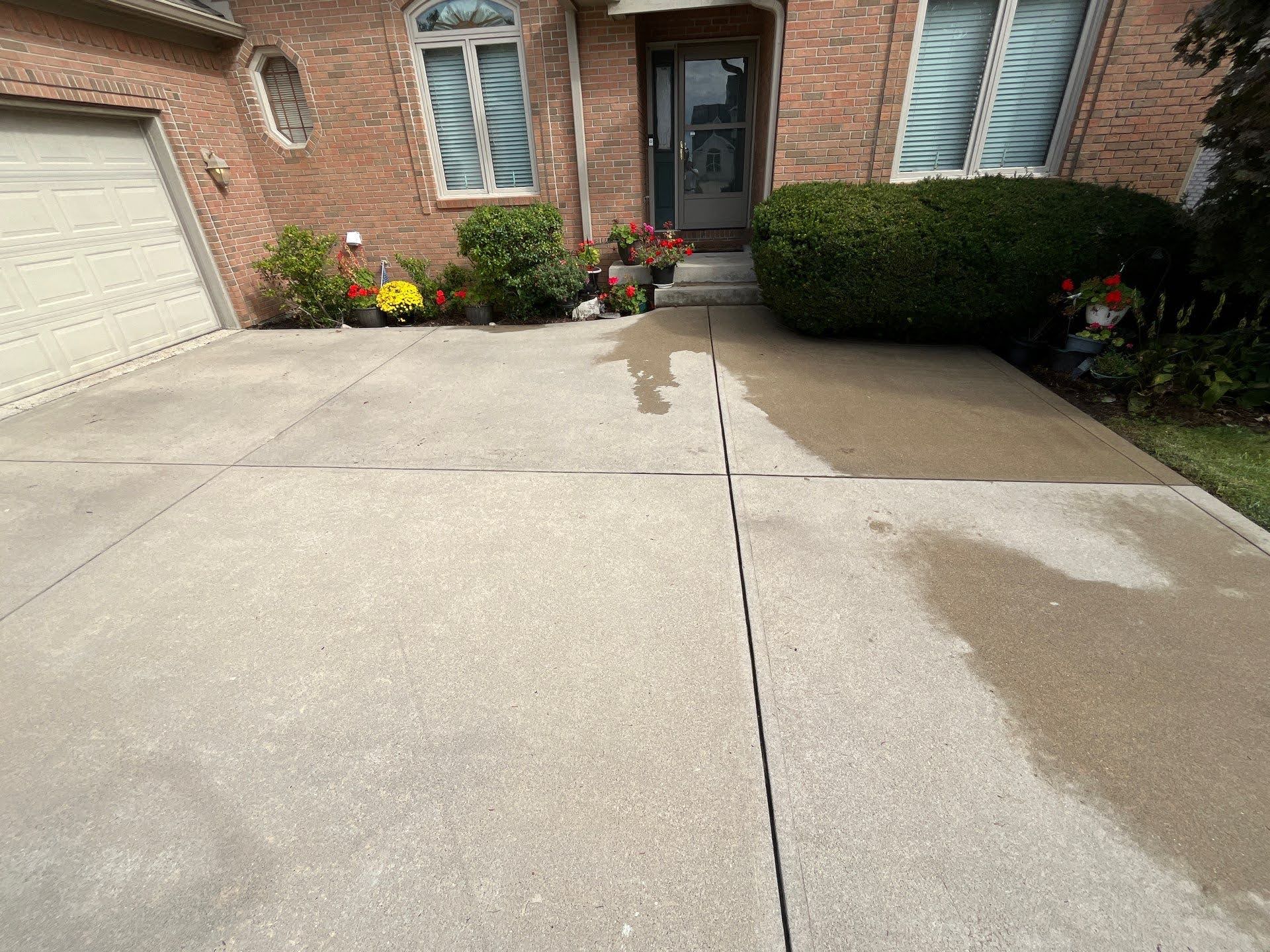 Concrete Driveway Cleaning Before After Lawton Residence: Wet driveway and clean concrete patio.
