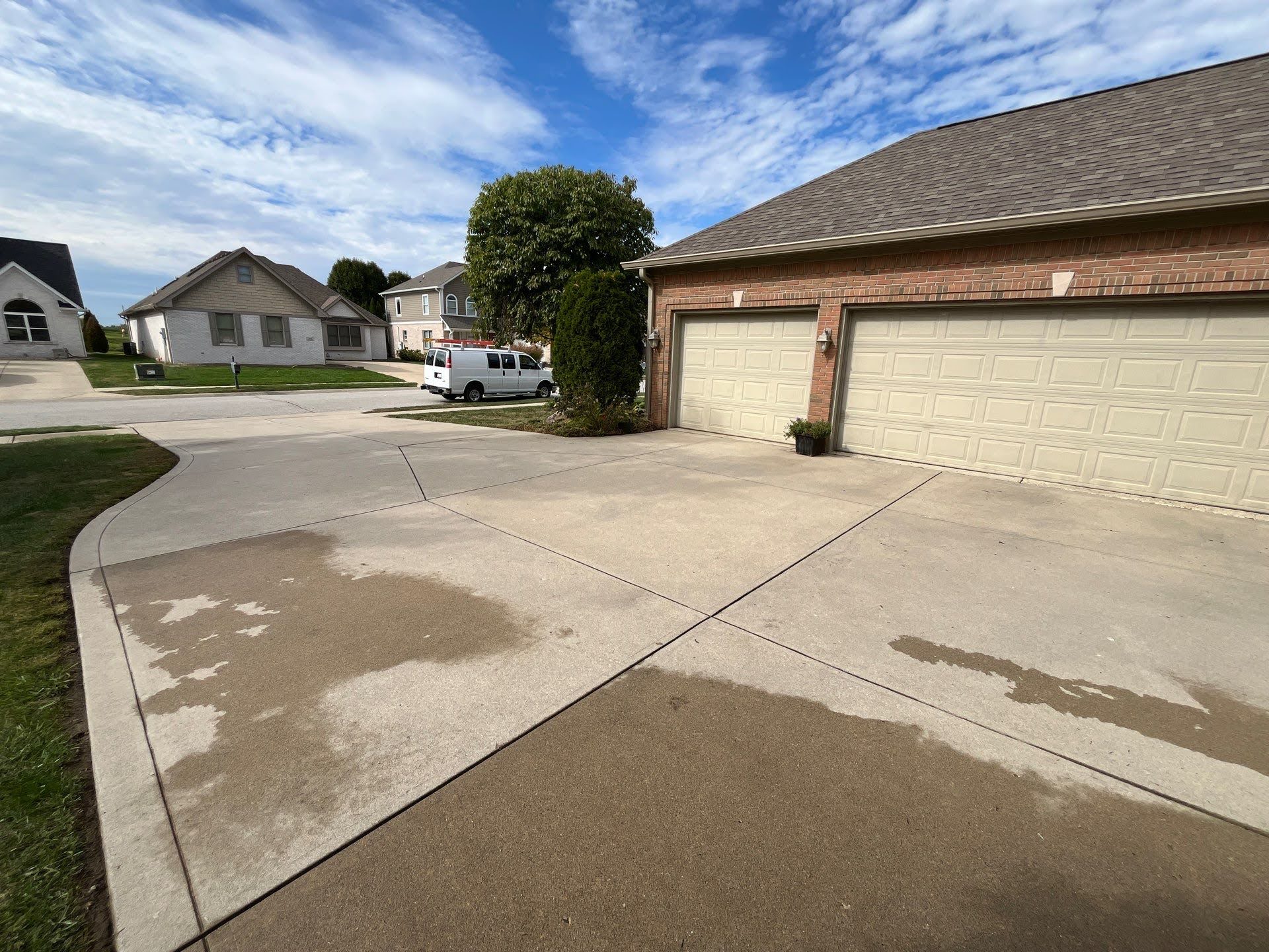 Concrete Driveway With Wet Spots And Garage Lawton Residence driveway and garage on a cloudy day
