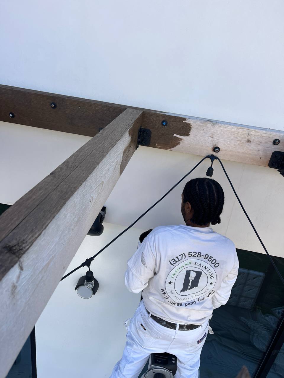 Indiana Painting Crew Working On Wood Beams Indiana Painting worker staining Cava Canopy exterior wood beams.