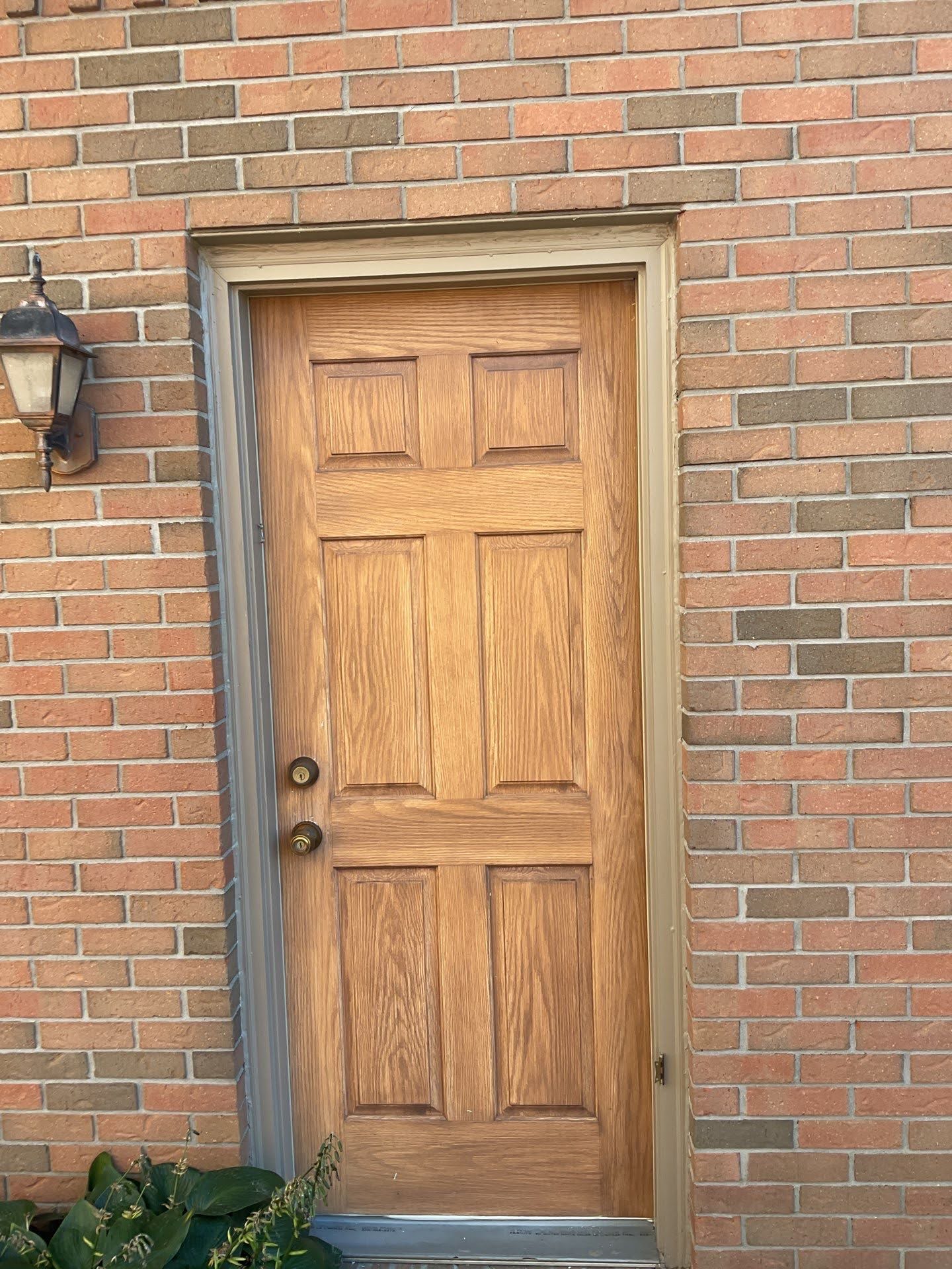Light Wood Entry Door Brick Wall Light brown wooden exterior door on a brick wall