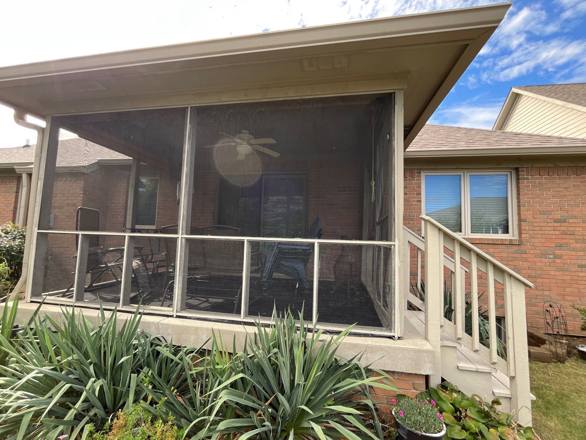 Screened Porch With Outdoor Furniture Screened porch addition on Lawton Residence, exterior view with deck and landscaping