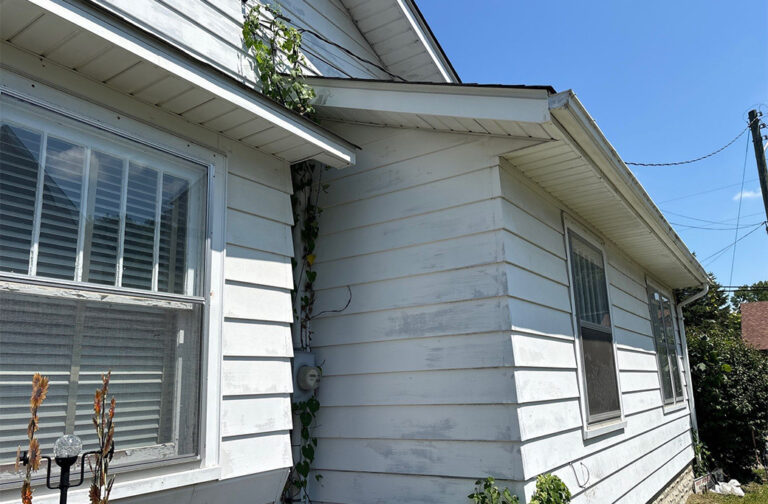 Worn white exterior paint on Indiana house siding, showing peeling paint.