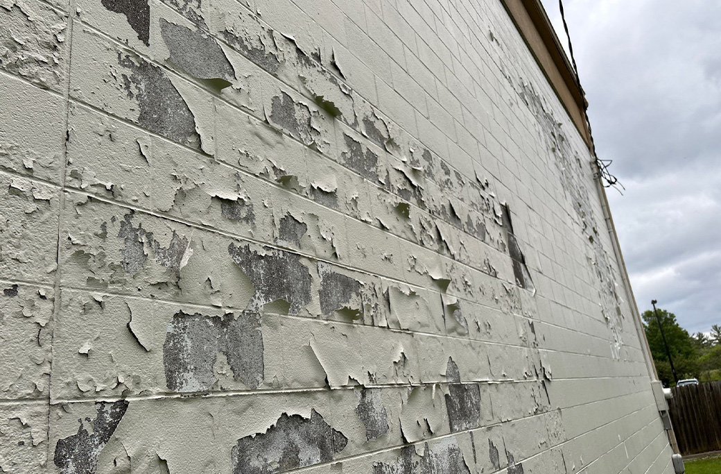 Peeling commercial exterior paint showing signs that repainting is needed