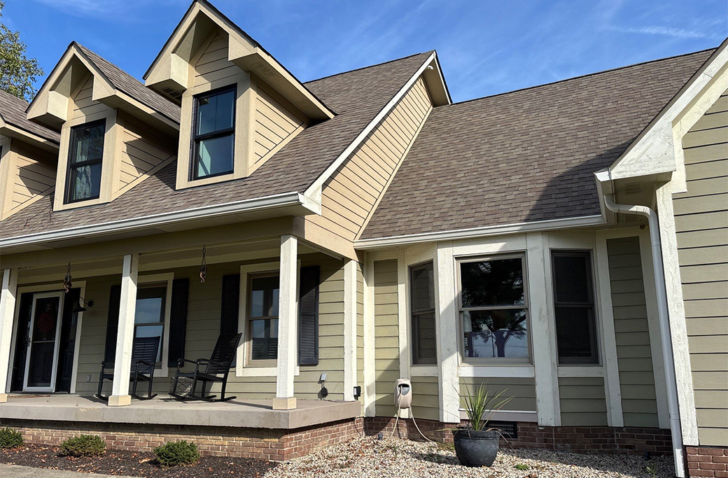 Weathered house exterior showing signs of needing a repaint, with peeling paint and faded siding.