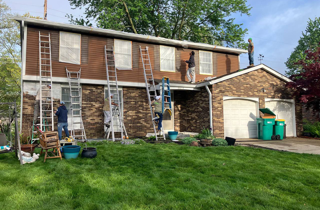Exterior siding being scraped and sanded before painting