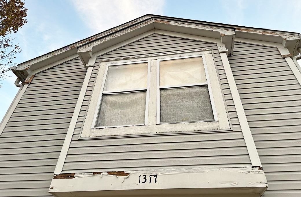 Peeling paint on house siding and window trim, house number 1317
