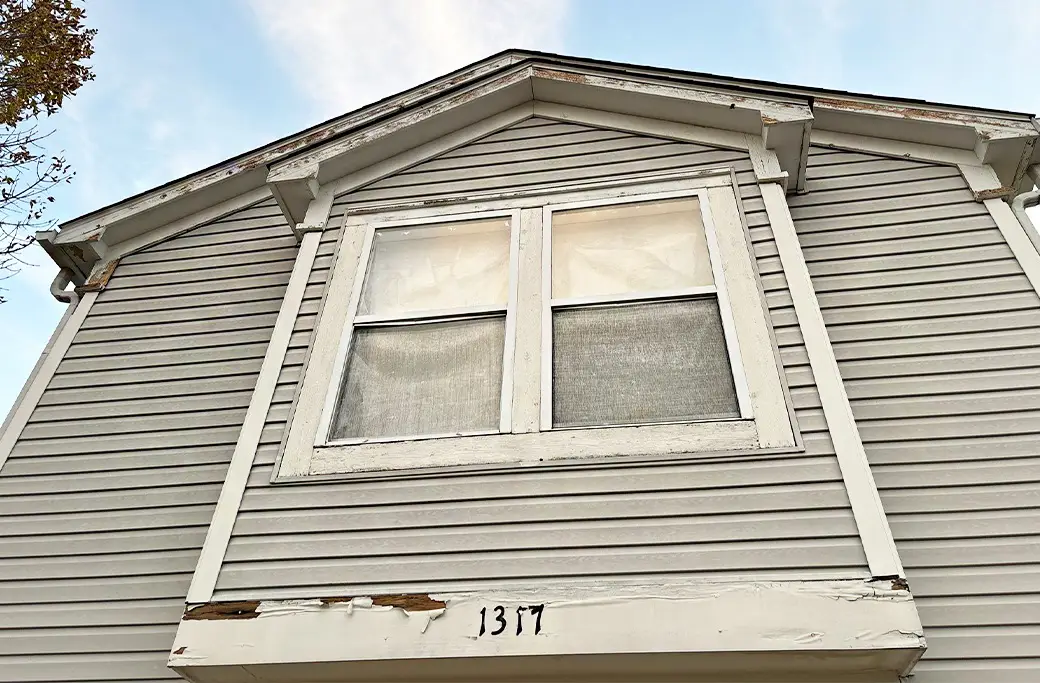 Peeling paint on house siding and window trim, house number 1317