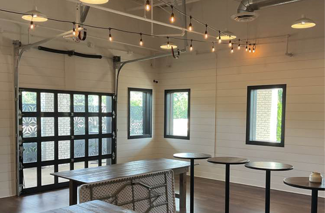 Modern office space with industrial garage door and string lights