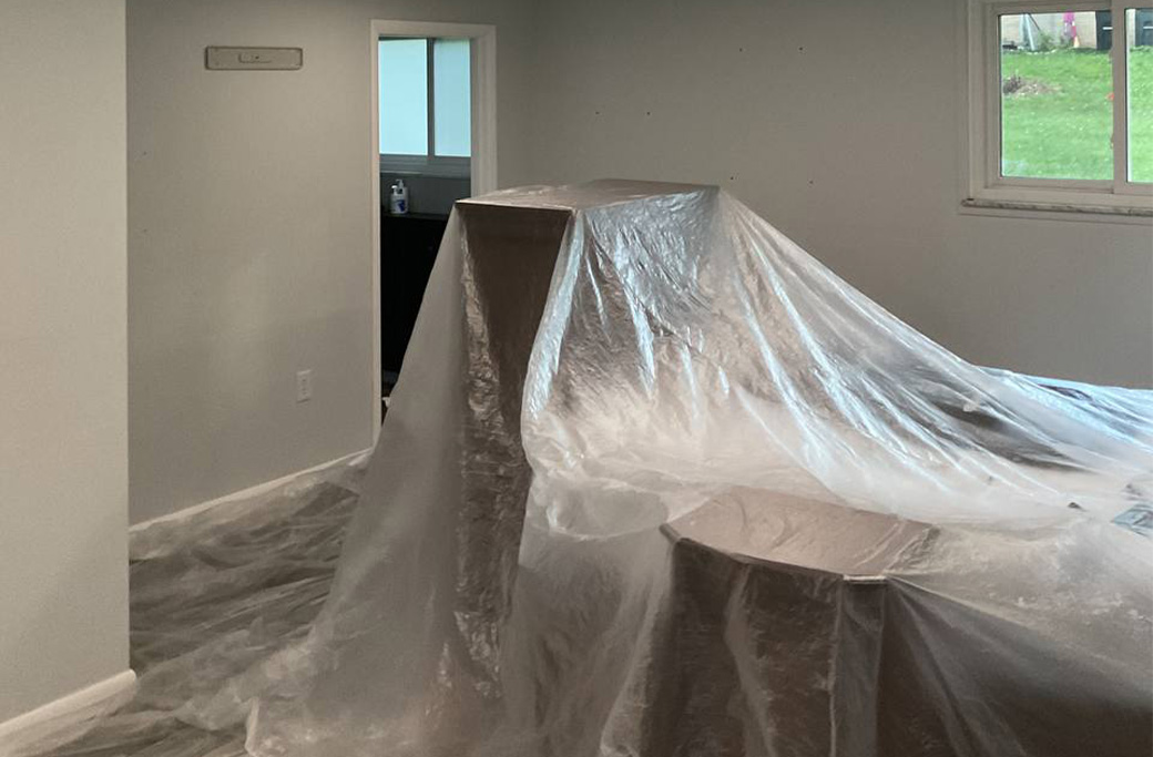 Furniture covered to protect it from dust and paint spatter during interior painting