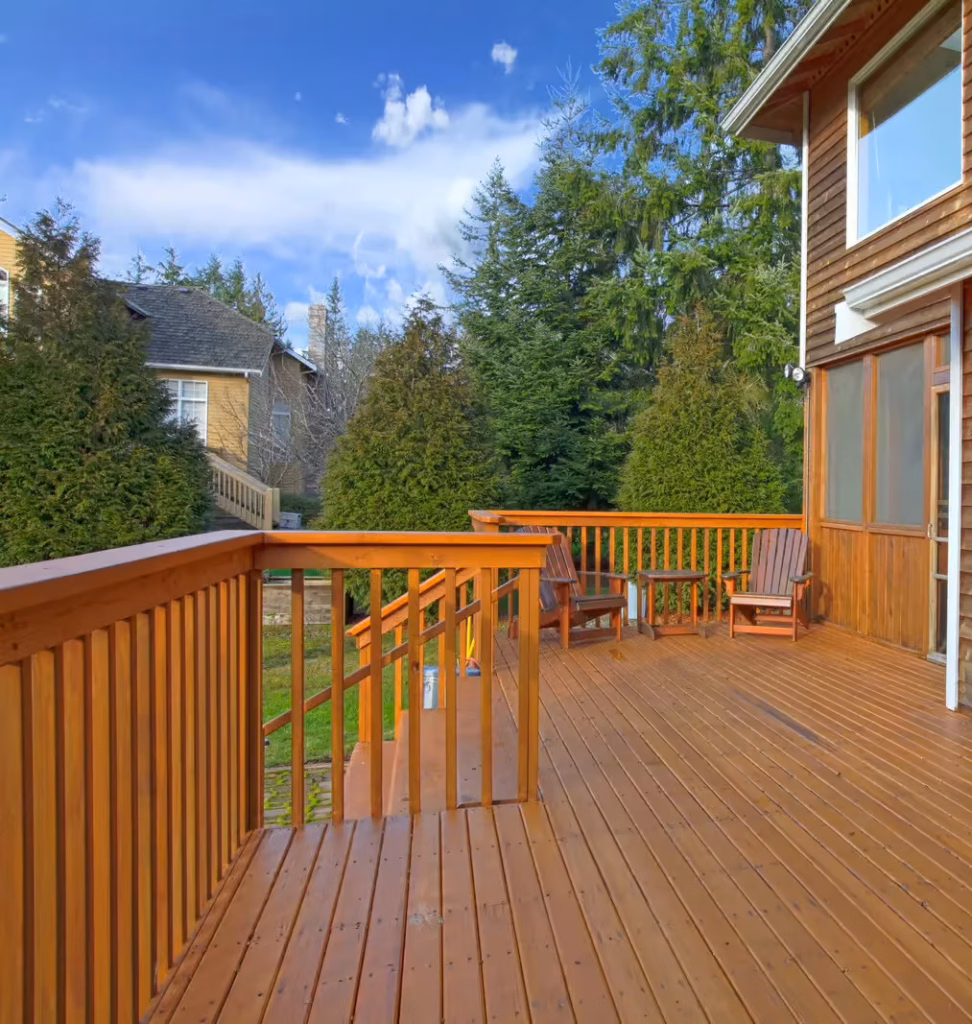 Stained wooden deck with chairs and trees